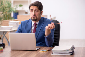 Young male employee sitting at workplace