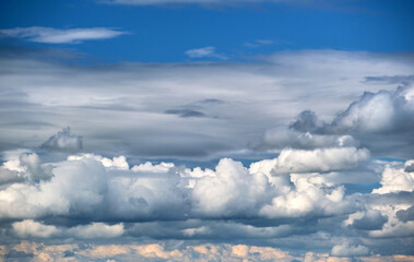 Bright landscape of white puffy cumulus clouds on blue clear sky