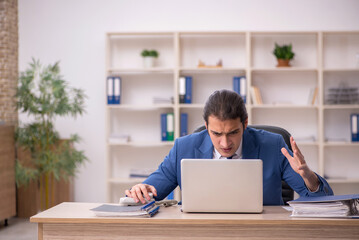 Young male employee sitting in the office