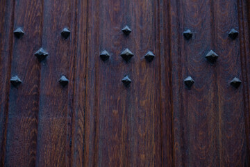vieille porte en bois avec des clous en fer pouvant servir de fond de page, de texture ou d'arrière-plan 