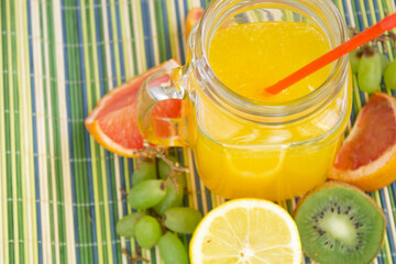 closeup drink with lemon and fruits kiwi grapes grapefruit on table drinking juice beverage liquid...