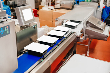 modern poultry processing plant.Meat processing in food industry.Packing of meat slices in boxes on a conveyor belt.Line for the production of semi-finished meat products.
