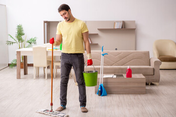 Young male contractor cleaning the house