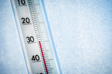 The thermometer shows a low temperature of minus 30 Celsius. Weather forecast. A frosty day and ice...