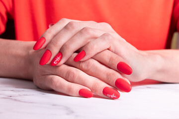 Fototapeta premium Red matte manicure on female hands for valentines day