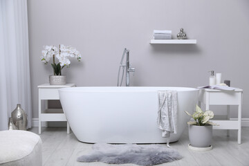 White tub and beautiful plants in bathroom, Interior design
