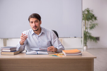 Young male teacher in front of whiteboard