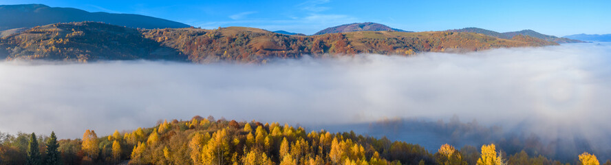 Obraz premium Autumn mountain landscape panorama. Peaks above the fog. Drone view.