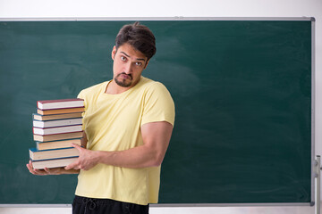 Young male student holding many books