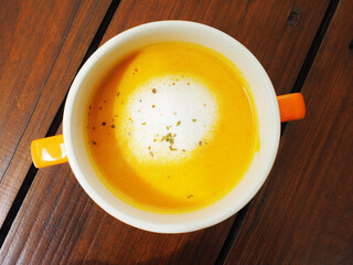 Pumpkin cream soup on wood table