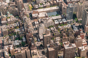 Fototapeta premium Aerial top view of New York City building roofs. Bird's eye view from helicopter of cityscape metropolis infrastructure, traffic, residential district and yellow cabs moving along streets and avenues