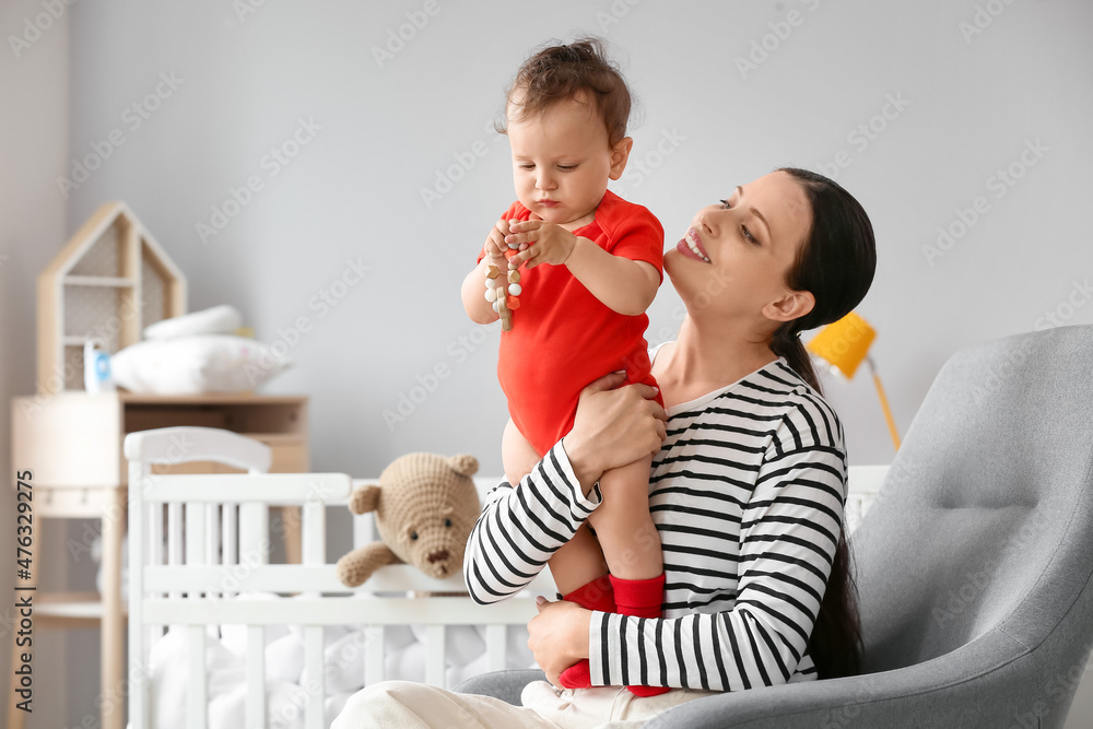 Canvas Prints Young mother holding her little baby with toy in bedroom