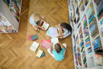Top view of children studying on floor in library