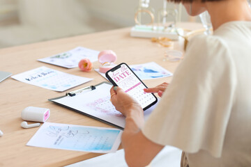 Female wedding planner with phone working in office