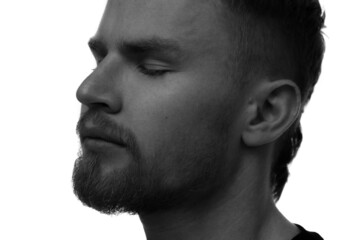 Obraz premium A black and white portrait of a handsome man with closed eyes.