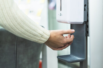 Cleaning, washing hands using automatic sanitizer dispenser concept. Today people lifestyle...