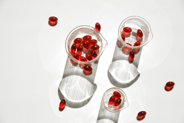 Krill oil gelatin capsules in laboratory transparent flasks on a white background.omega fatty...