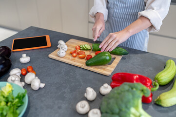 Woman cutting vegetables on a cutting board