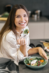 Smiling happy woman eating with appetite