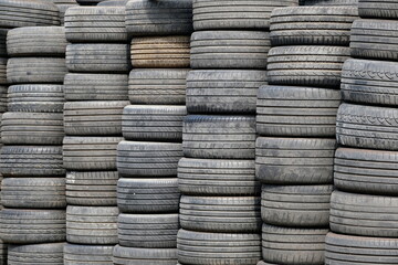 Piles of dark grey used tyres
