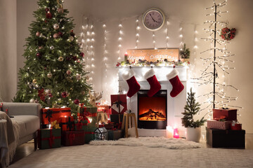 Interior of living room with Christmas tree, fireplace and glowing garland at night