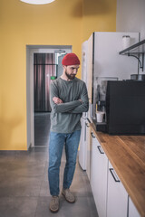 Guy with folded hands near coffee machine in office