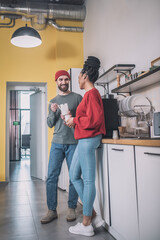 Fototapeta premium Guy and girl communicating in office kitchen