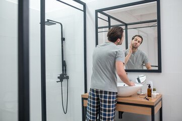 Man near the mirror scrutinizing himself