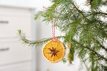 Fototapeta na wymiar Beautiful handmade Christmas toy hanging on tree in room, closeup