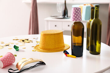 Empty bottles with decor on table in room after party