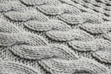 Grey knitted fabric with beautiful pattern as background, closeup