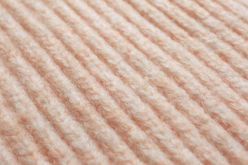 Beautiful pale pink knitted fabric as background, closeup