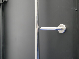 metal door handle on black wooden door.