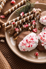 Plate with tasty candy cane cookies on table, closeup