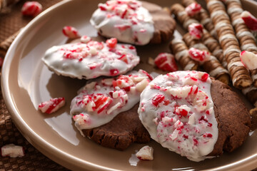 Plate with tasty candy cane cookies on table, closeup