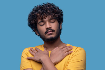 Obraz premium Calm Indian guy with arms crossed on his chest