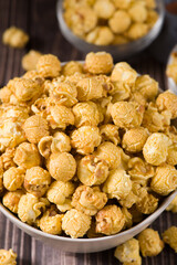 close up of popcorn in a bow  on wood background