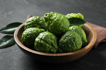 Fresh ripe bergamot fruits in bowl on black table