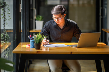 Asian Handsome young smiling businessman working with documents in the office