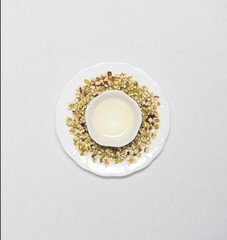 a cup of flower tea with dried flower tea leaves around