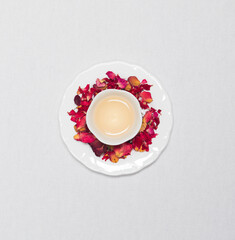 Obraz na płótnie Canvas a cup of flower tea with dried flower tea leaves around