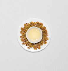 Obraz na płótnie Canvas a cup of flower tea with dried flower tea leaves around