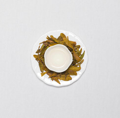 a cup of flower tea with dried flower tea leaves around