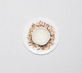 a cup of flower tea with dried flower tea leaves around