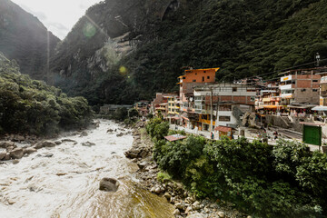 Fast paced Urubamba river flows past a town, Cusco, Peru