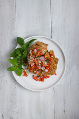 Ayam Geprek sambal matah. Popular fusion street food dishes of smashed southern fried chicken, topped with sambal matah.