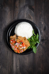 Ayam Geprek sambal matah. Popular fusion street food dishes of smashed southern fried chicken, topped with sambal matah.
