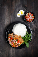 Ayam Geprek sambal matah. Popular fusion street food dishes of smashed southern fried chicken, topped with sambal matah.