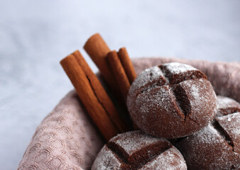 round homemade gingerbread with cinnamon and powdered sugar on a gray background