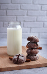 homemade round gingerbread with cinnamon in powdered sugar on a board with milk